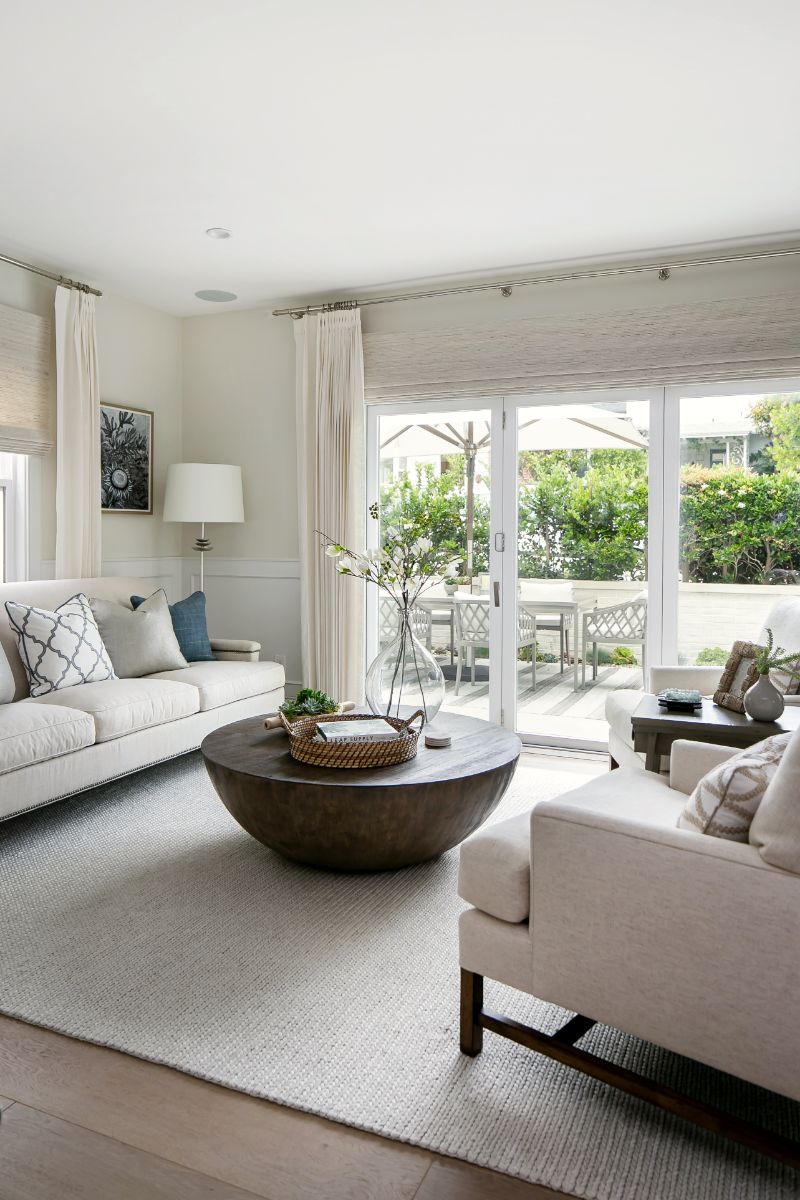 Living room seating with blue accent pillows and linen drapery