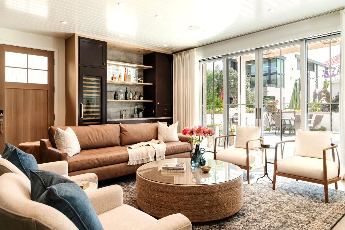 Living room with cognac leather sofa and glass walls open to the patio